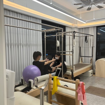 짐볼과 밴드를 놓고 회원의 자세를 봐 주는 강사.