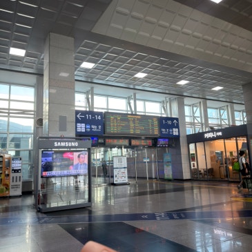 열차 출발 안내 전광판과 승강장 번호 표지가 걸린 역 대합실.