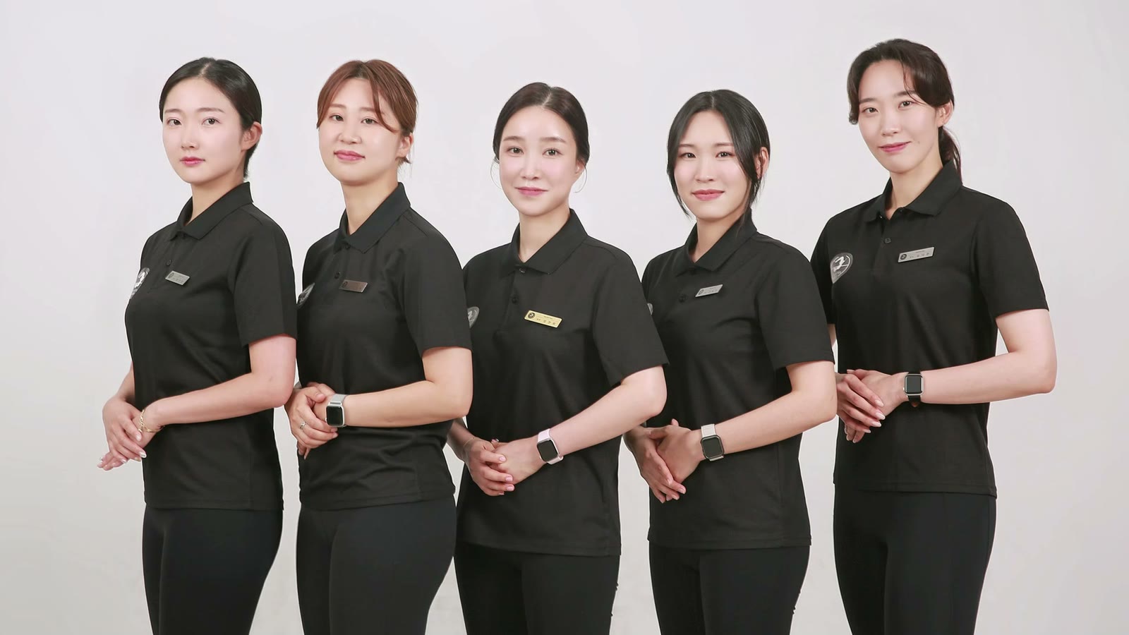 검은 유니폼을 입고 나란히 선 필라테스휘 강사진.